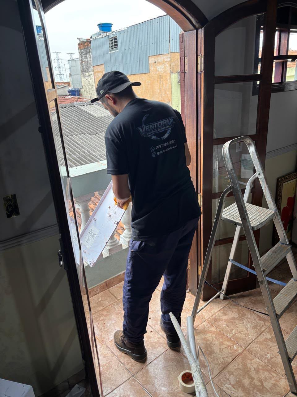 Técnico da Ventorix com uniforme da empresa instalando evaporadora de ar-condicionado em residência