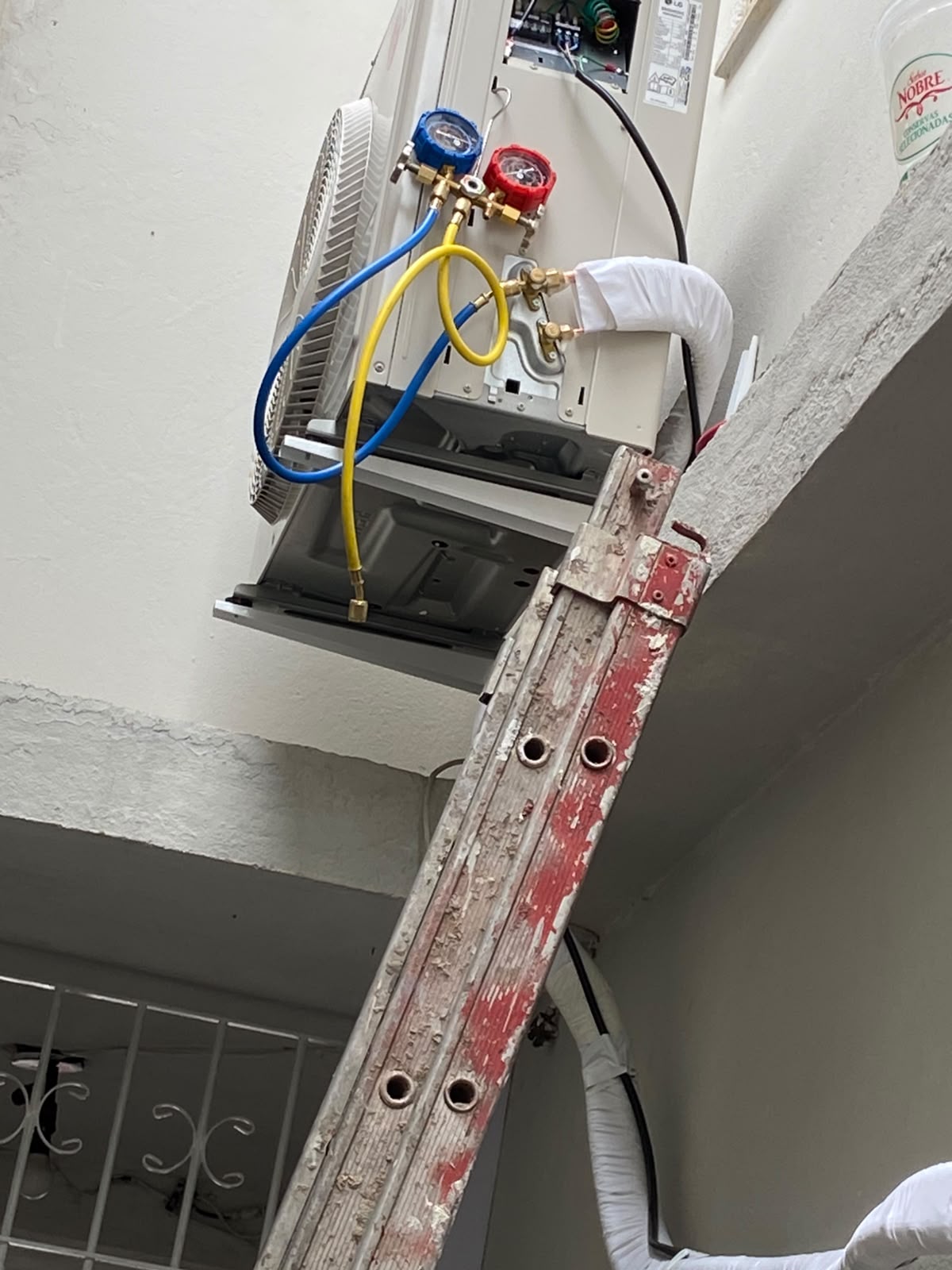 Técnico da Ventorix fazendo vácuo e teste de estanqueidade na condensadora de um split instalado em fachada